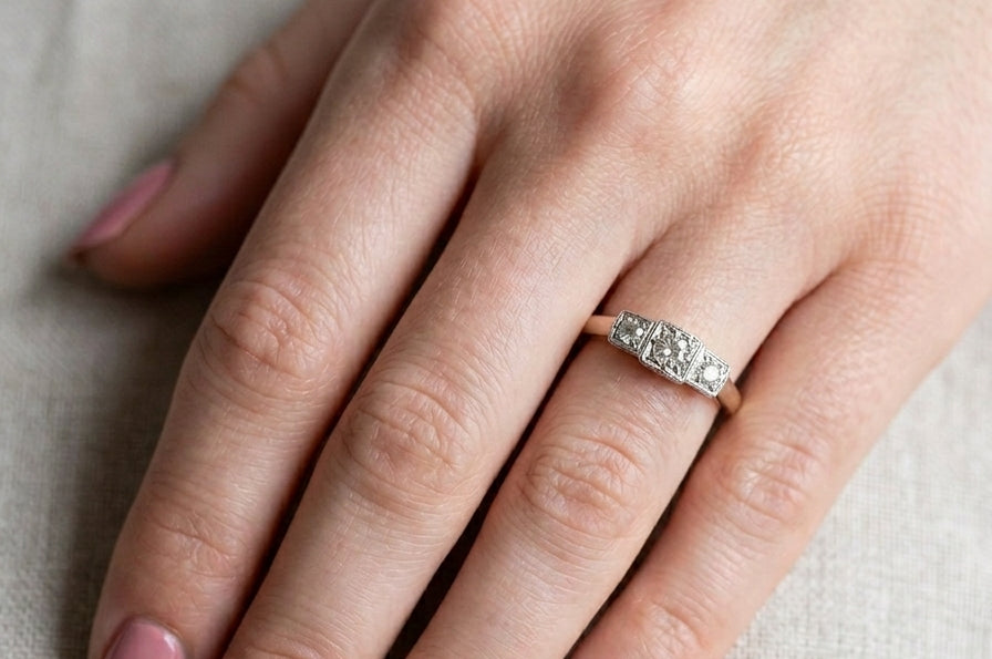 hand A vintage trilogy ring. Set with three old brilliant cut white diamonds, centre 3mm and each side a 2.4mm diamond. Total estimated at 0.20 carats, colour H-j, clarity Si