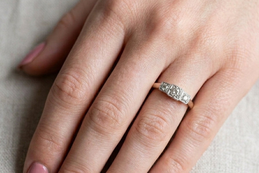 hand A vintage trilogy ring. Set with three old brilliant cut white diamonds, centre 3mm and each side a 2.4mm diamond. Total estimated at 0.20 carats, colour H-j, clarity Si