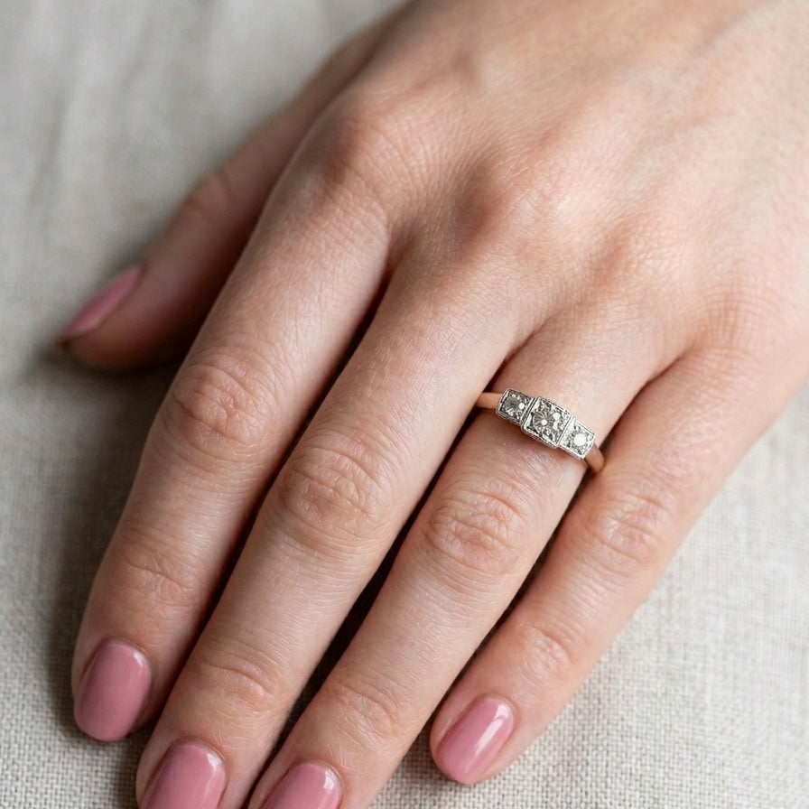 hand A vintage trilogy ring. Set with three old brilliant cut white diamonds, centre 3mm and each side a 2.4mm diamond. Total estimated at 0.20 carats, colour H-j, clarity Si