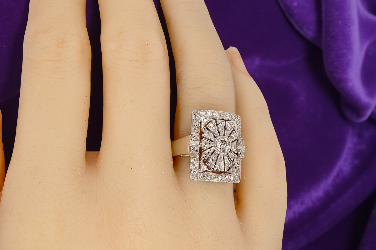 diamond ring on a hand with a purple fabric background