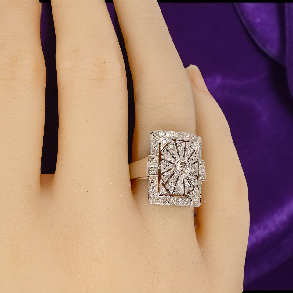 diamond ring on a hand with a purple fabric background