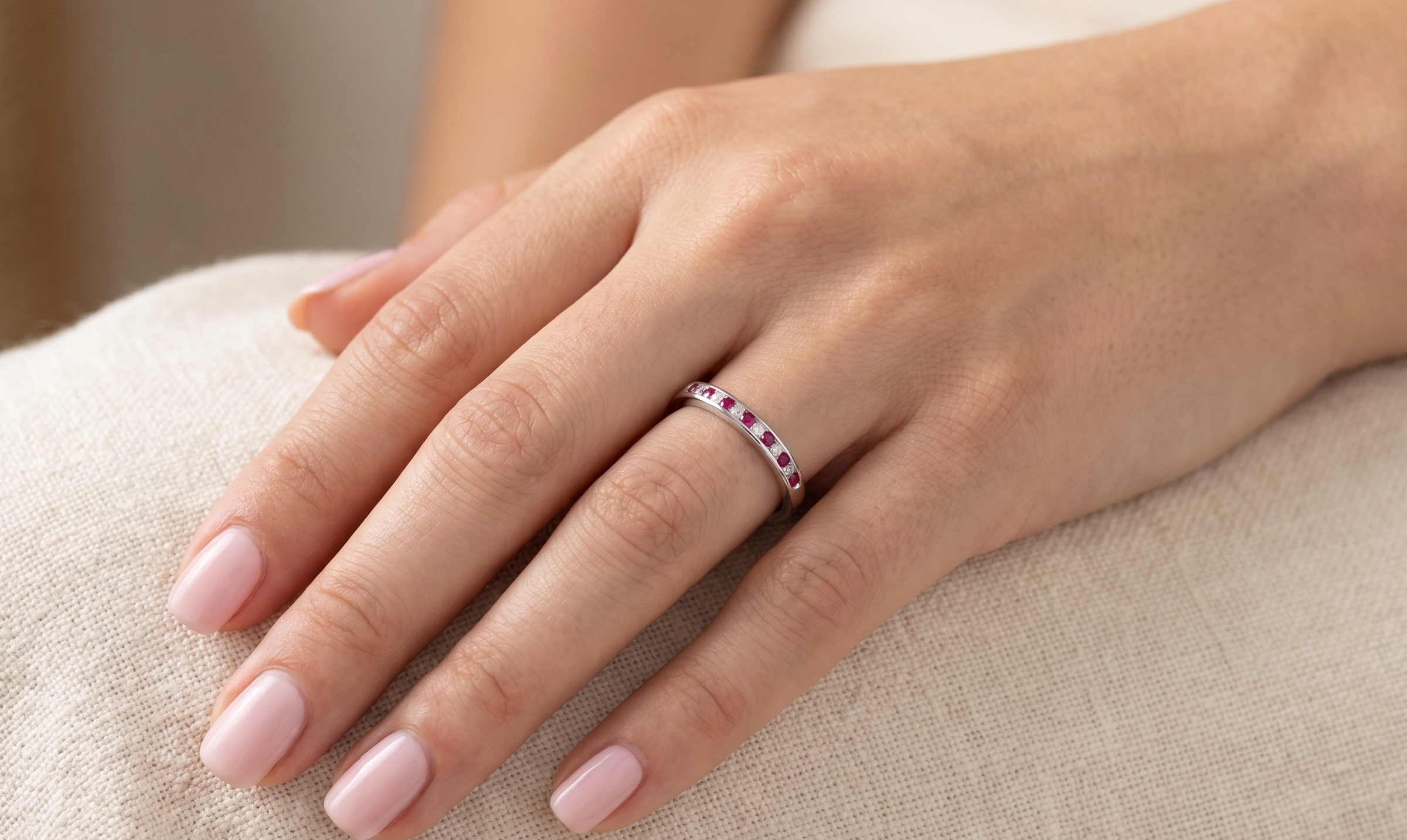 hand A white gold half hoop eternity ring. Set with seven round rubies and six brilliant cut white diamonds