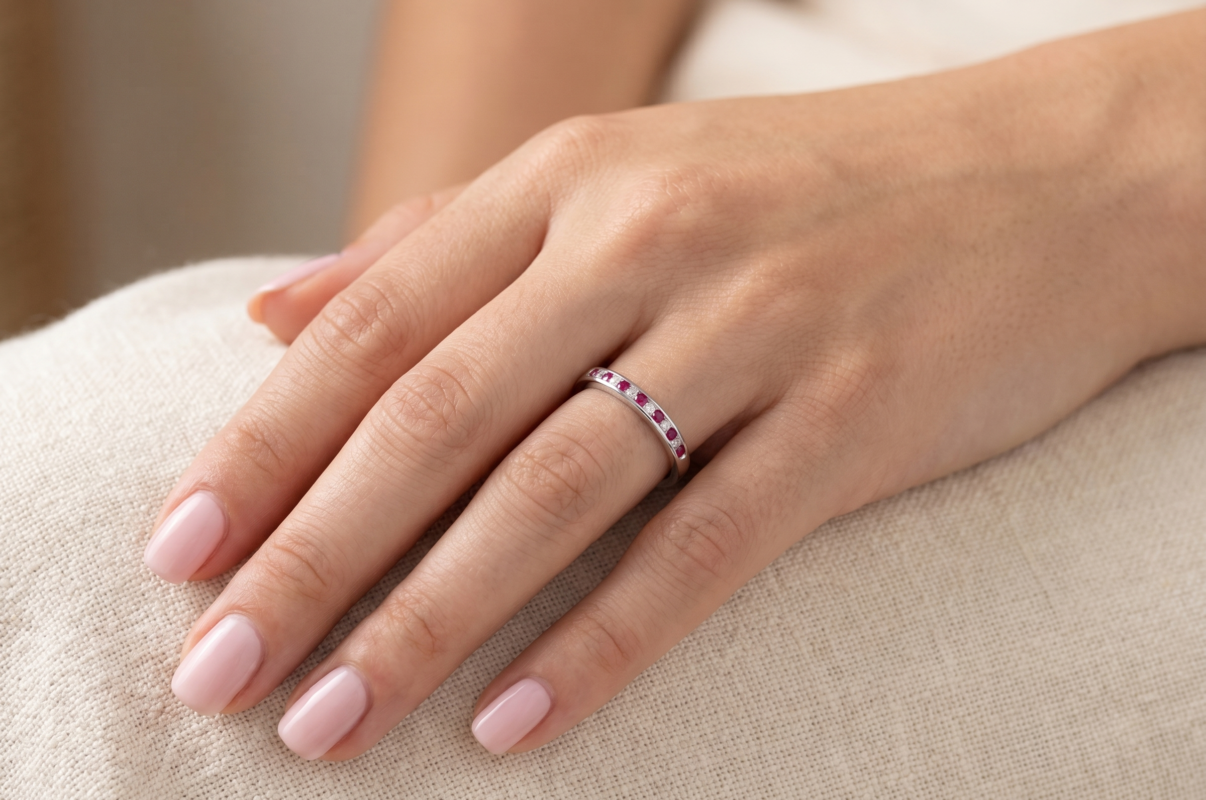 hand A white gold half hoop eternity ring. Set with seven round rubies and six brilliant cut white diamonds