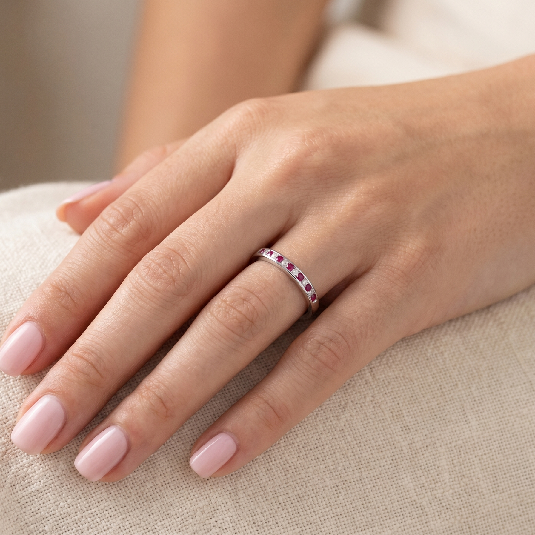 hand A white gold half hoop eternity ring. Set with seven round rubies and six brilliant cut white diamonds