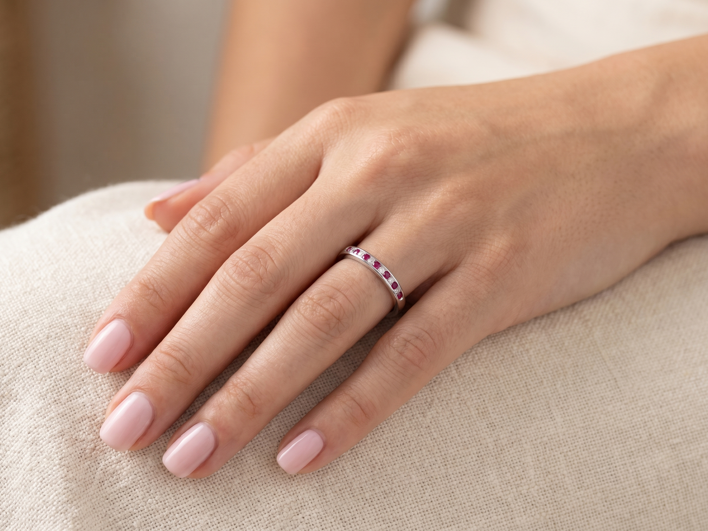 hand A white gold half hoop eternity ring. Set with seven round rubies and six brilliant cut white diamonds