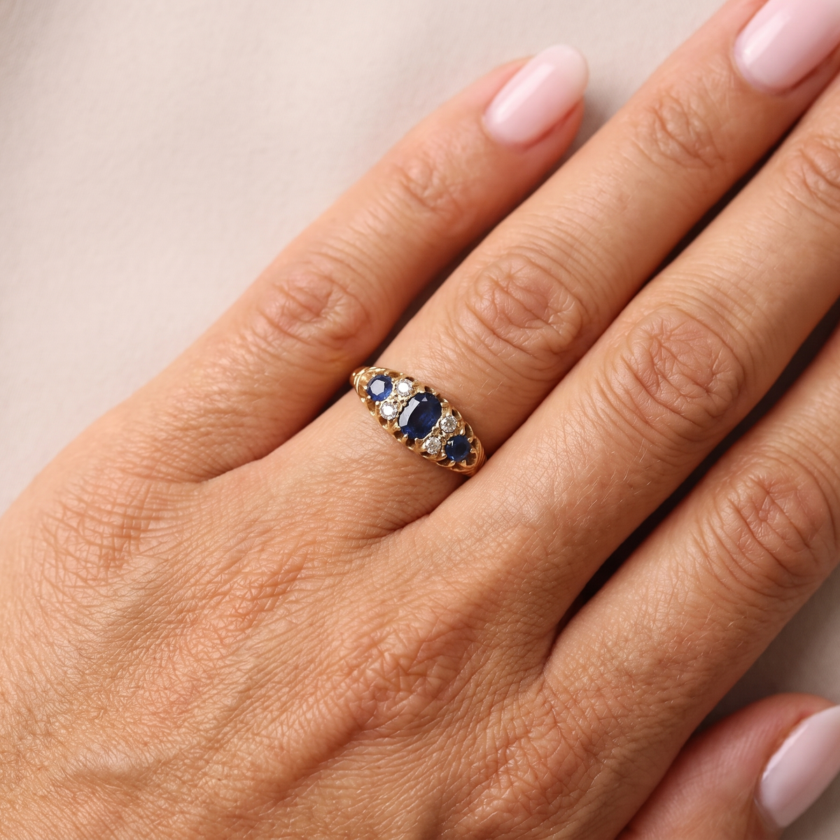 hand An 18 carat gold early 20th century ring set with three sapphires. Centre 5x3.8mm each end 3.8x2.8mm.