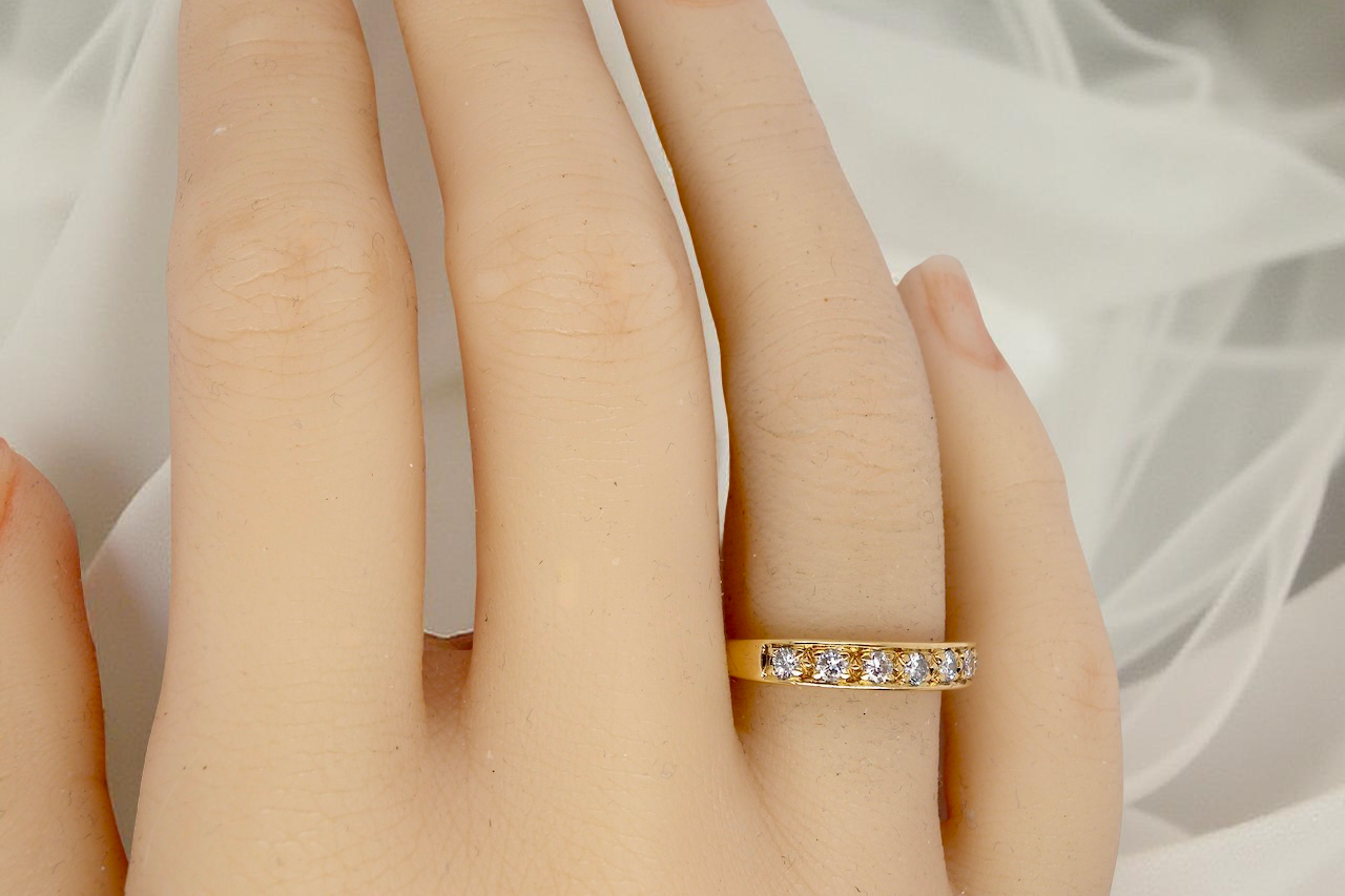 hand An 18 carat gold half-hoop eternity ring, set with eight brilliant-cut white diamonds