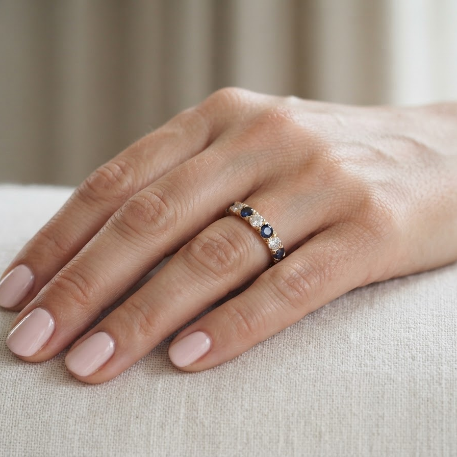 hand An 18 carat gold half hoop eternity ring. Set with four sapphires each 3.4mm (0.15 carats) and three diamonds, brilliant cut, 3.4mm (0.15 carats).