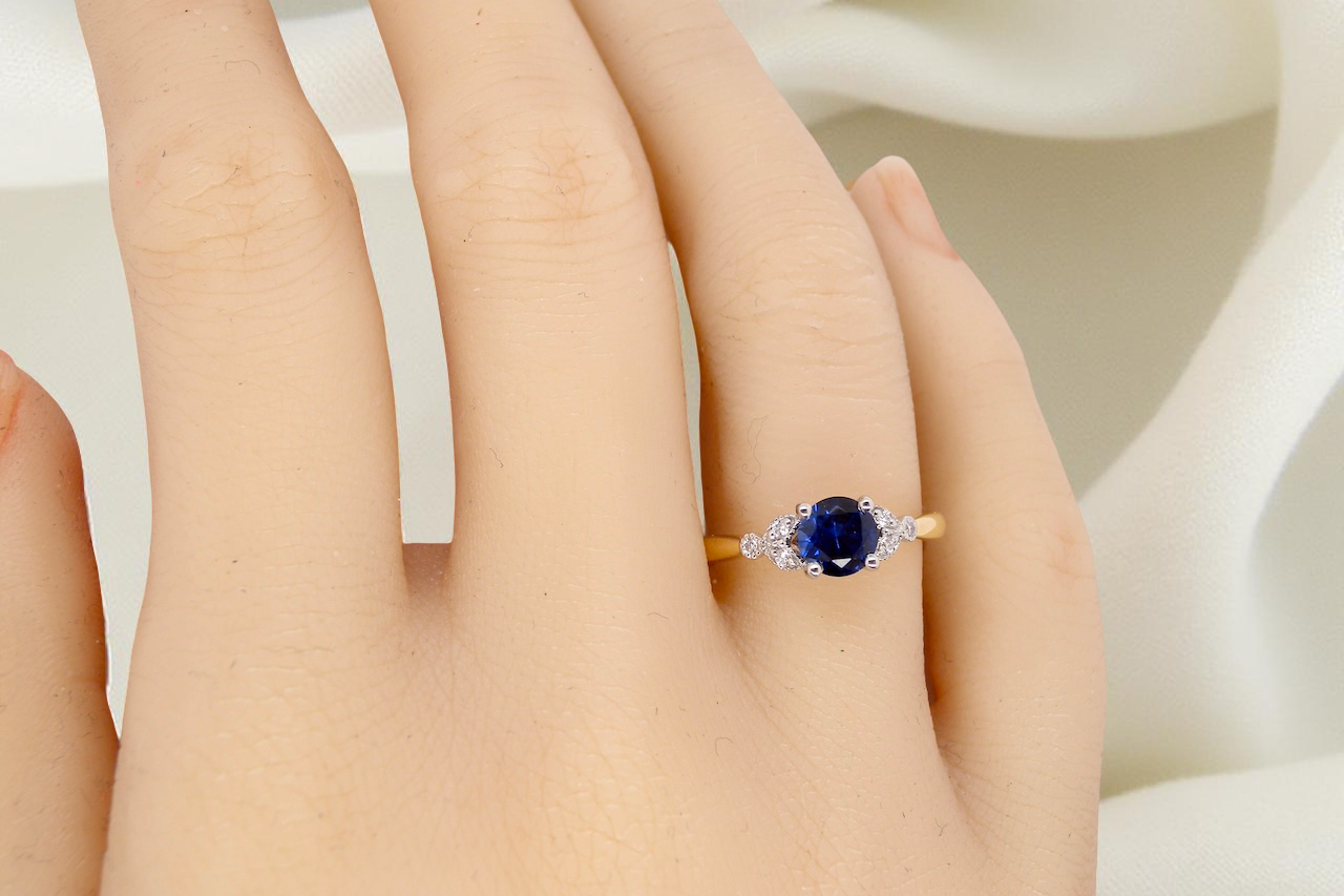 hand An 18 carat gold ring set with a vibrant blue sapphire,