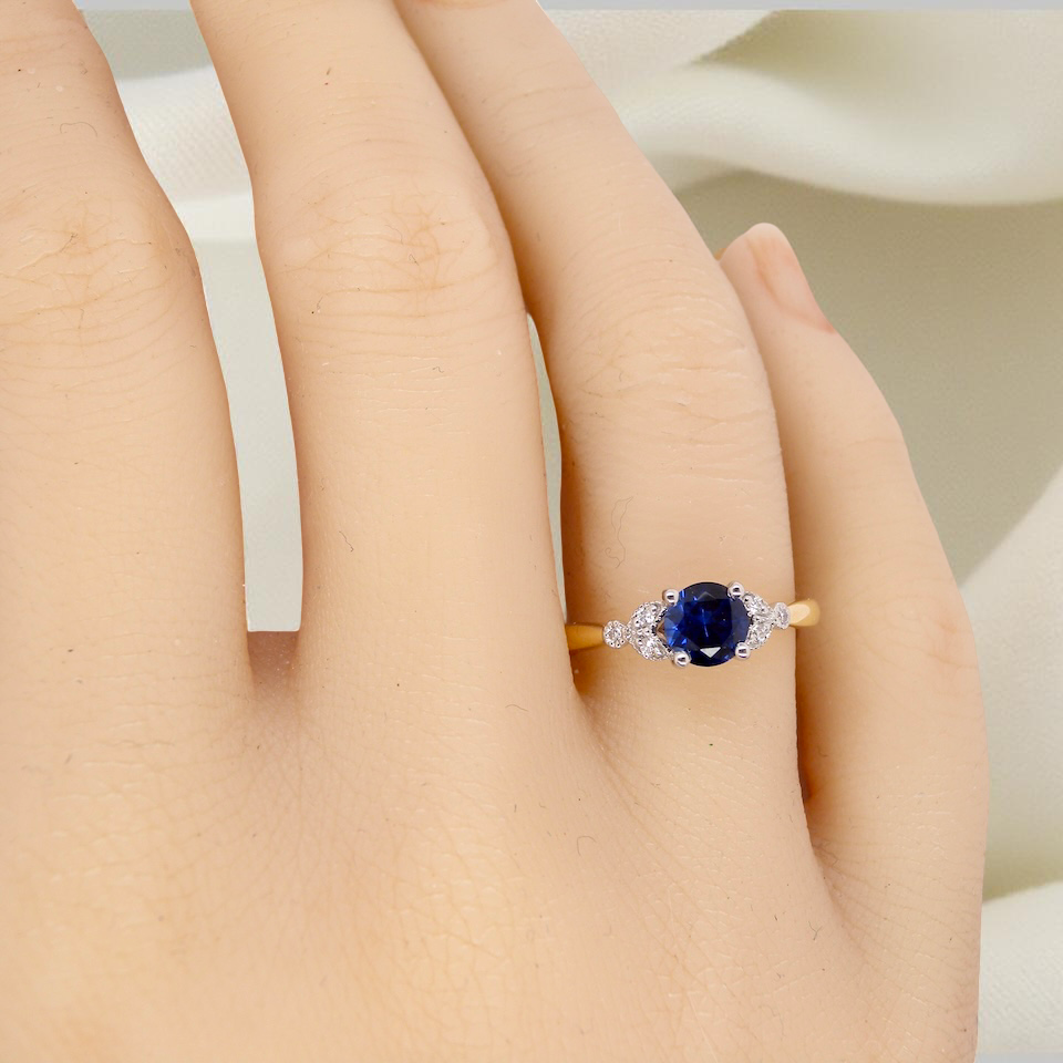 hand An 18 carat gold ring set with a vibrant blue sapphire,