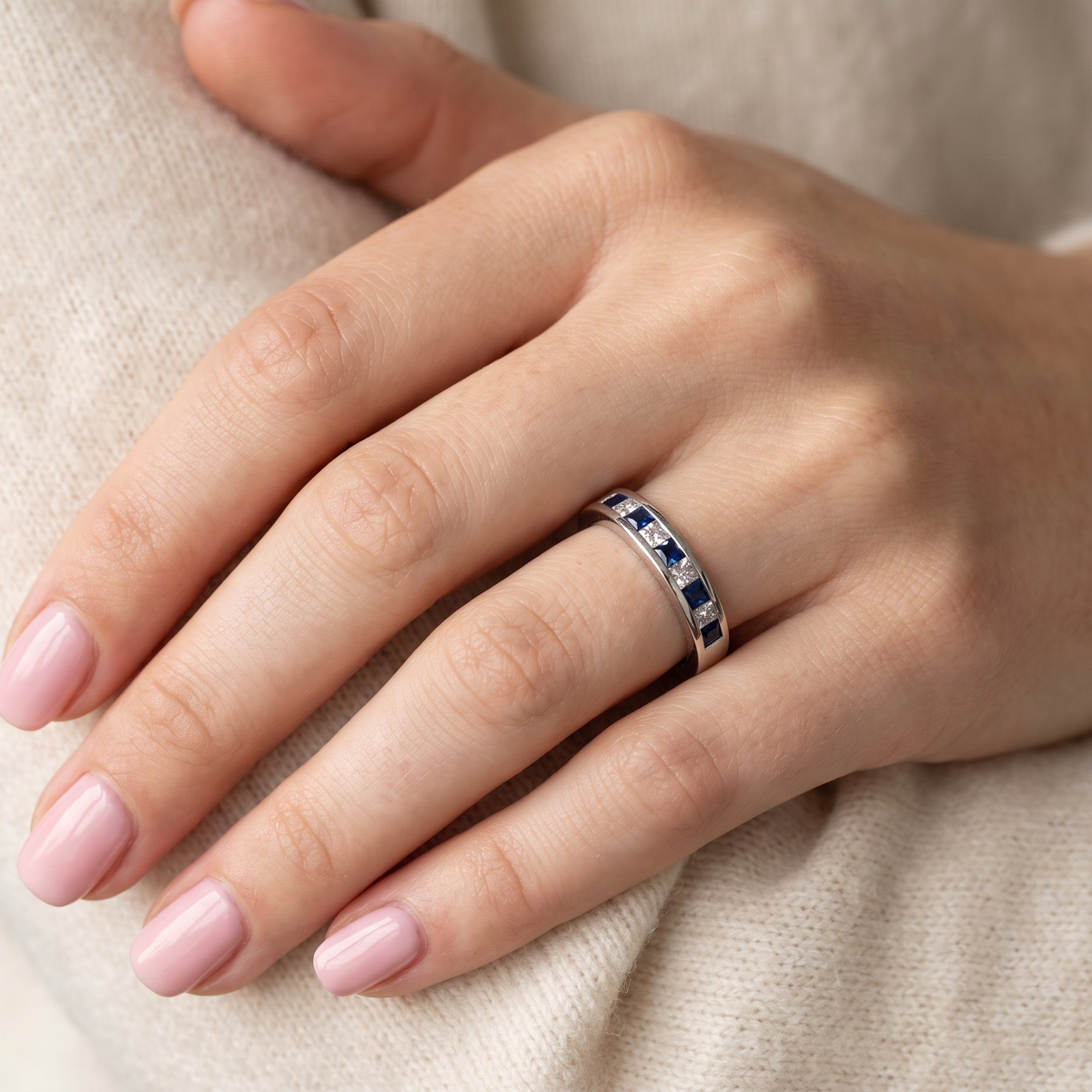 hand An 18 carat white gold half hoop eternity ring. Set with princess cut white diamonds, total of four- estimated 0.40 carats (2.4mm each) colour H-j, clarity Si.