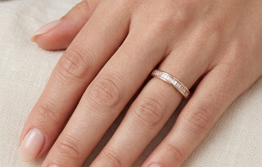 hand An 18 carat yellow gold half hoop eternity ring.
Set with thirty baguette cut white diamonds,