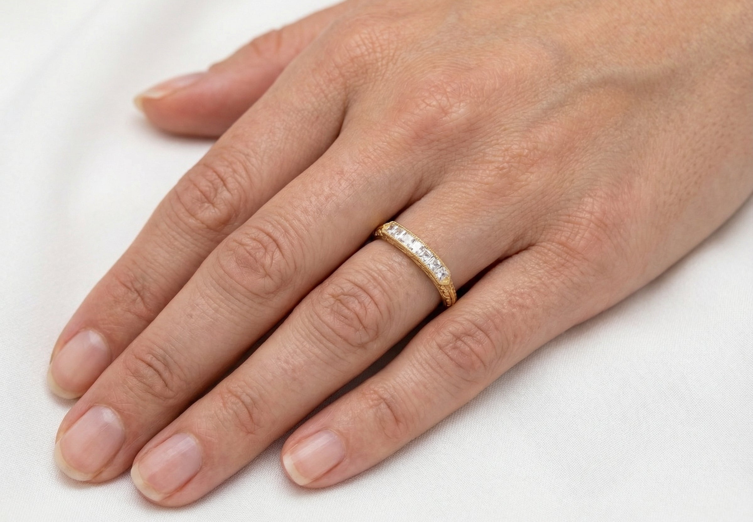 hand An attractive half hoop diamond eternity ring. Set with six step cut white diamonds, that sit side by side, the colour estimated at H-i, clarity Si.