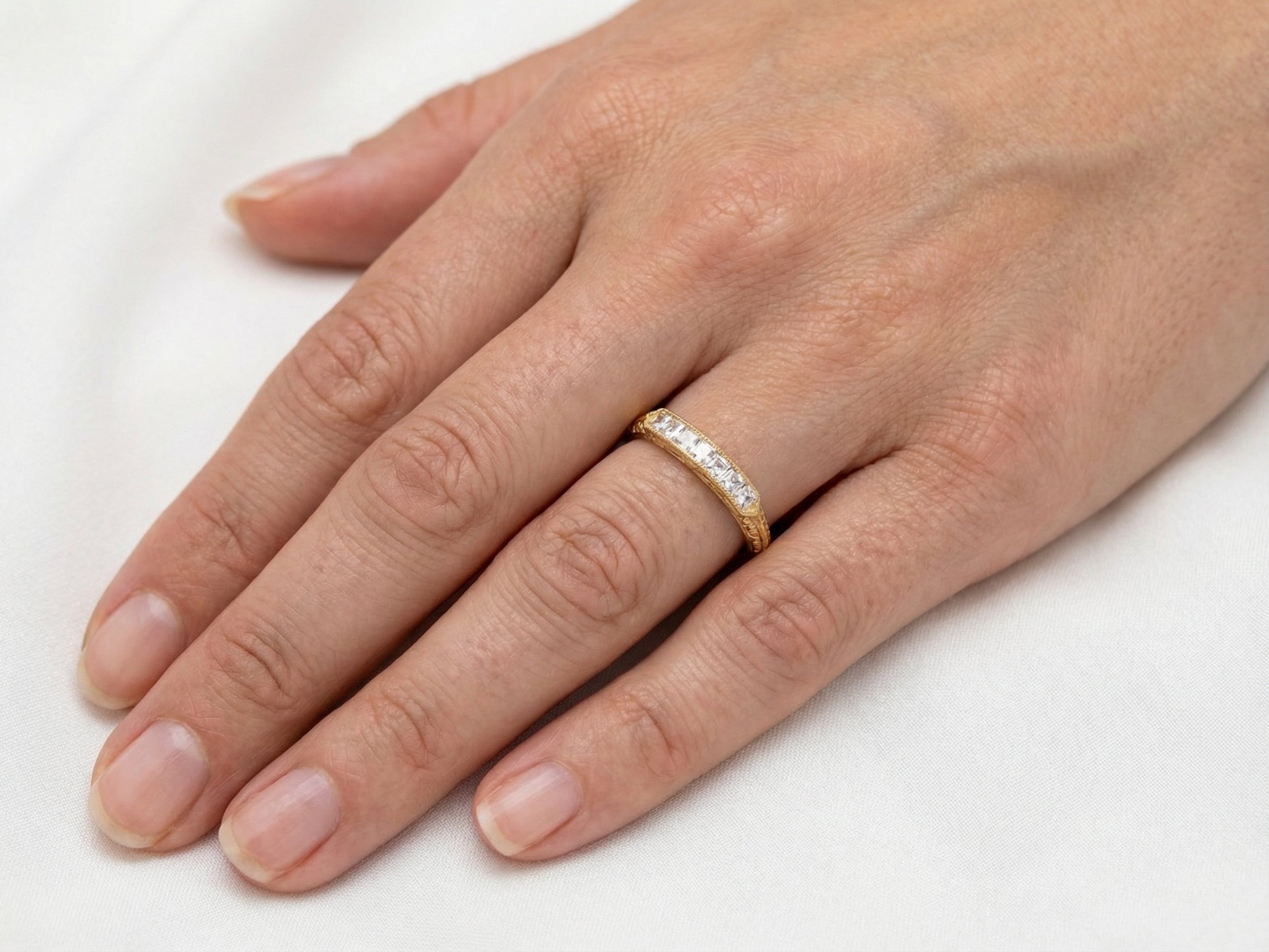 hand An attractive half hoop diamond eternity ring. Set with six step cut white diamonds, that sit side by side, the colour estimated at H-i, clarity Si.