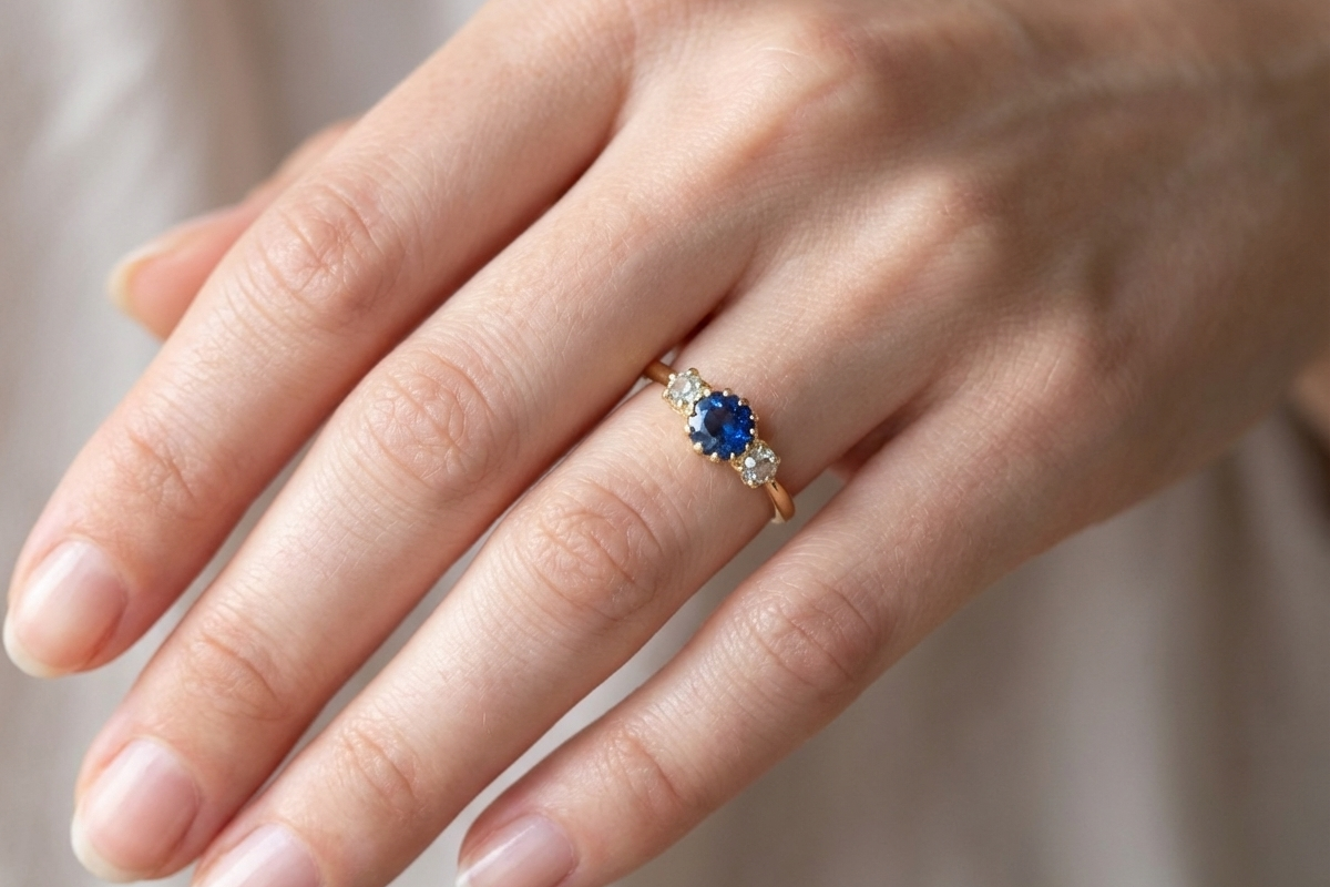 hand An early 20th-century trilogy ring set with a mid to dark cornflower blue sapphire,