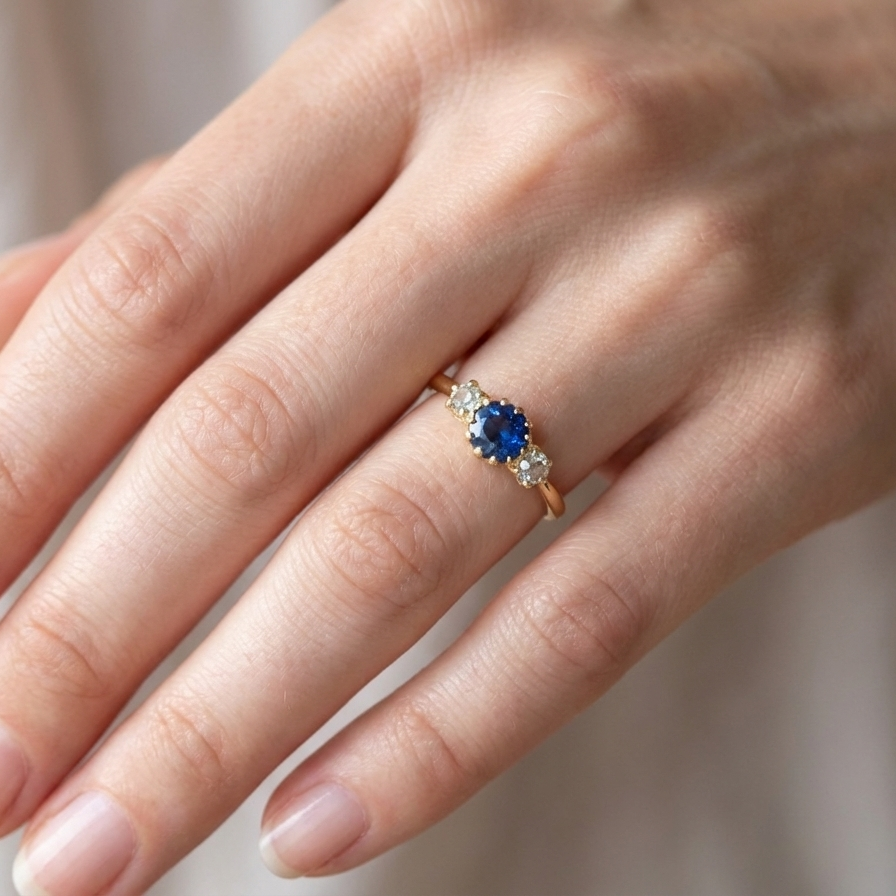 hand An early 20th-century trilogy ring set with a mid to dark cornflower blue sapphire,