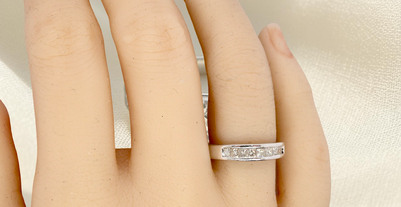 hand An elegant half-hoop eternity ring set with nine princess-cut white diamonds, each measuring approximately 2.5mm, with a total estimated diamond weight of 0.90 carats.