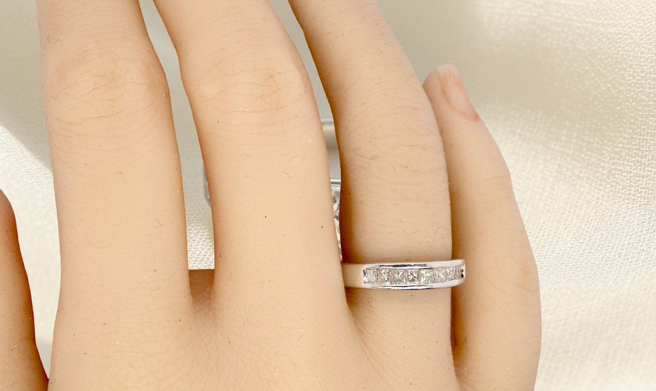 hand An elegant half-hoop eternity ring set with nine princess-cut white diamonds, each measuring approximately 2.5mm, with a total estimated diamond weight of 0.90 carats.