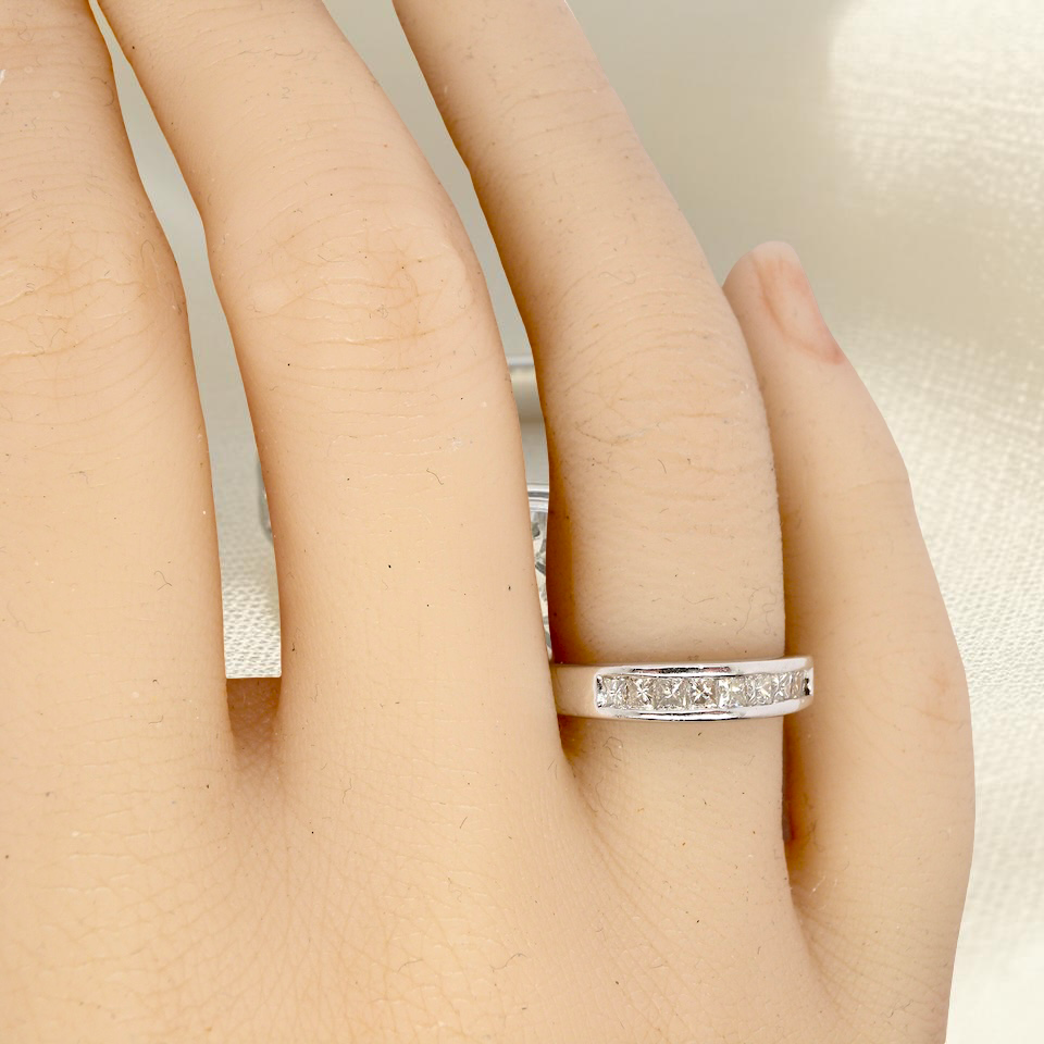 hand An elegant half-hoop eternity ring set with nine princess-cut white diamonds, each measuring approximately 2.5mm, with a total estimated diamond weight of 0.90 carats.