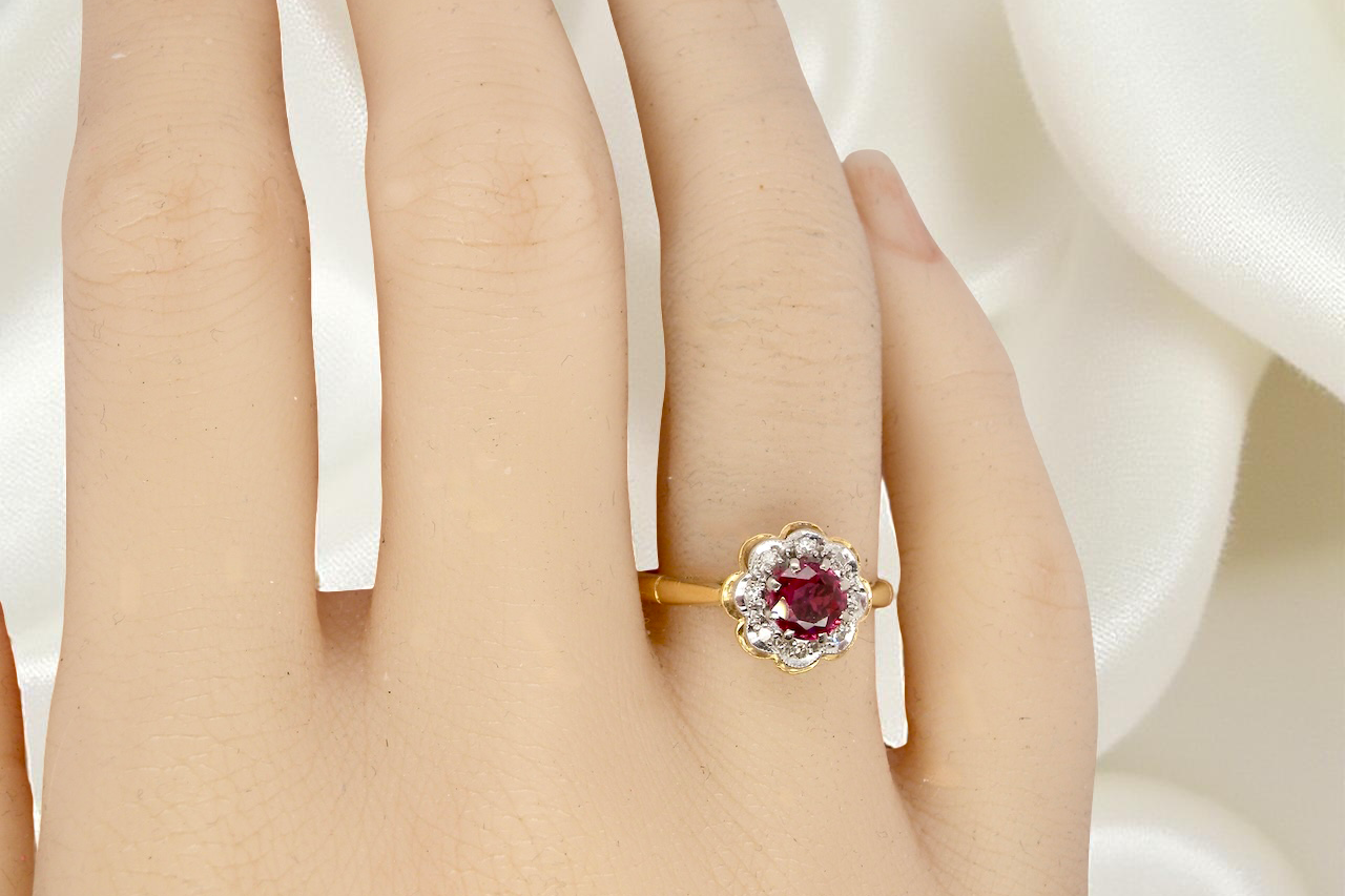 hand An exquisite vintage cluster ring centred around a 5 mm ruby,( 0.50 carats)
