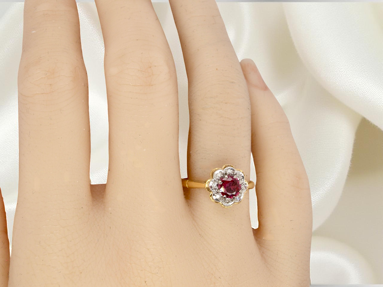 hand An exquisite vintage cluster ring centred around a 5 mm ruby,( 0.50 carats)