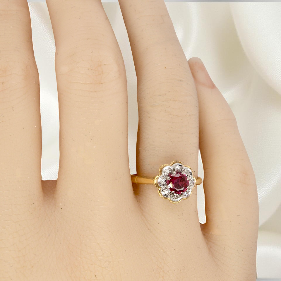 hand An exquisite vintage cluster ring centred around a 5 mm ruby,( 0.50 carats)