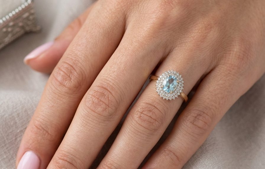 hand An impressive cluster ring that features to the centre an oval cut blue topaz gemstone, 8x6mm sky blue colour.
Complimented by an outer double halo of diamonds