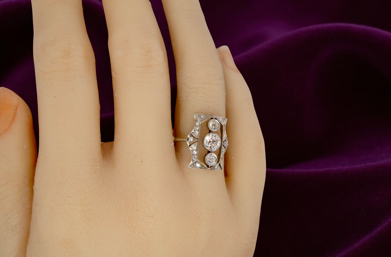 Diamond ring on a hand with a purple fabric background
