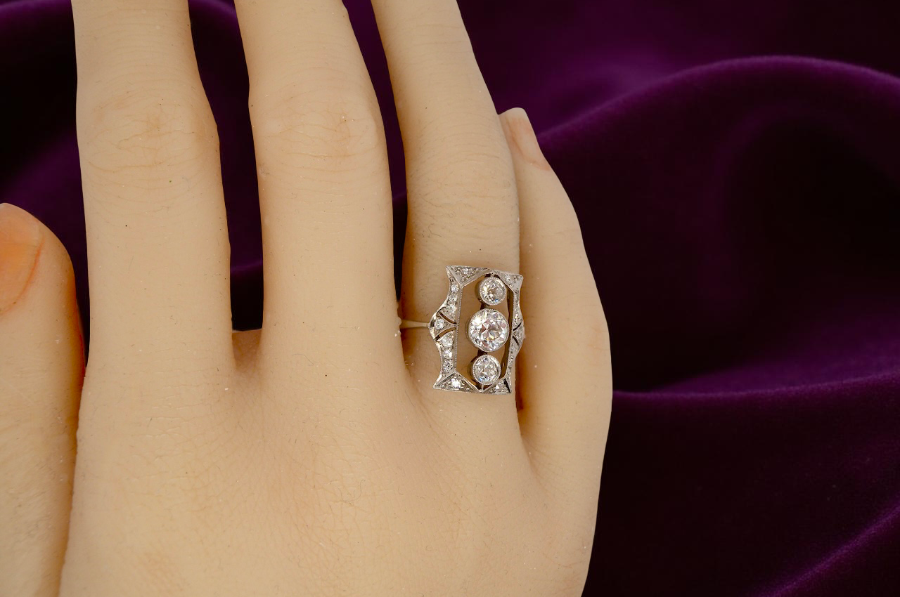 Diamond ring on a hand with a purple fabric background