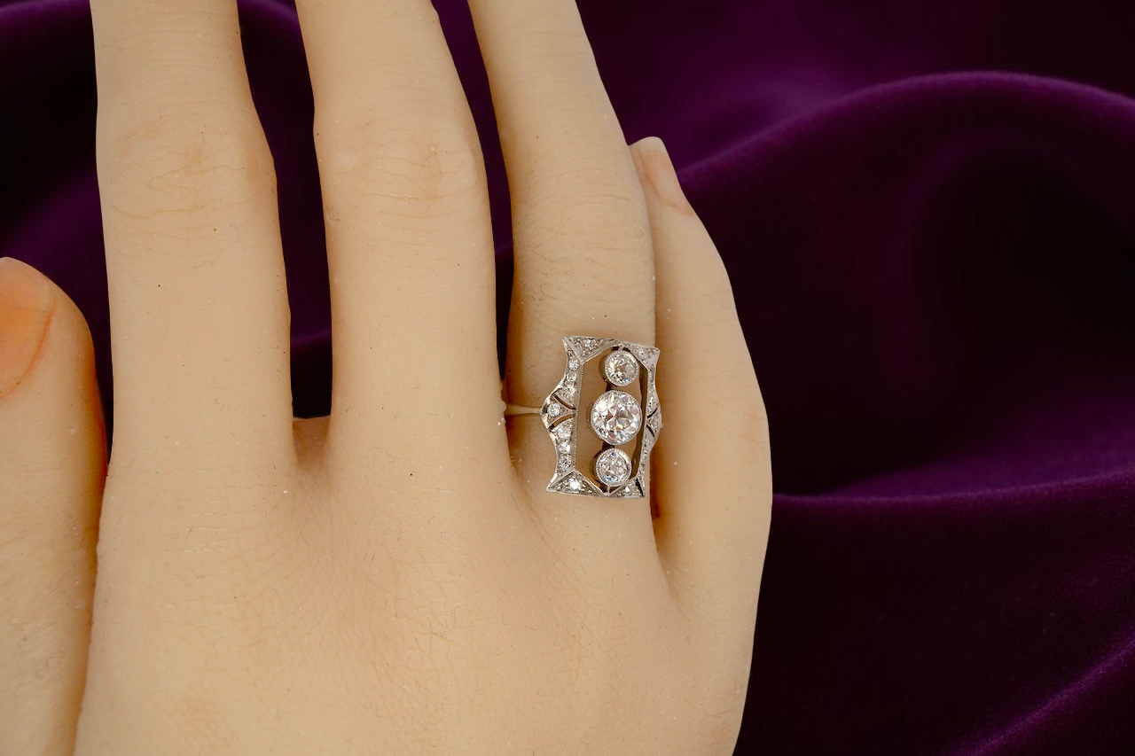 Diamond ring on a hand with a purple fabric background