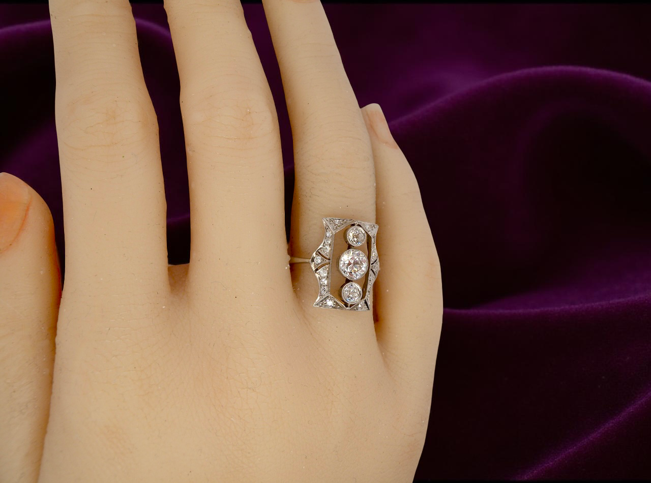 Diamond ring on a hand with a purple fabric background