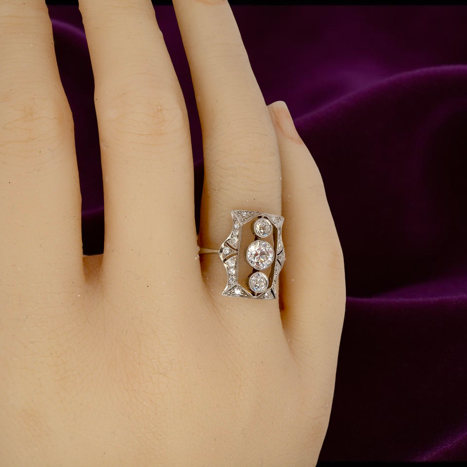 Diamond ring on a hand with a purple fabric background