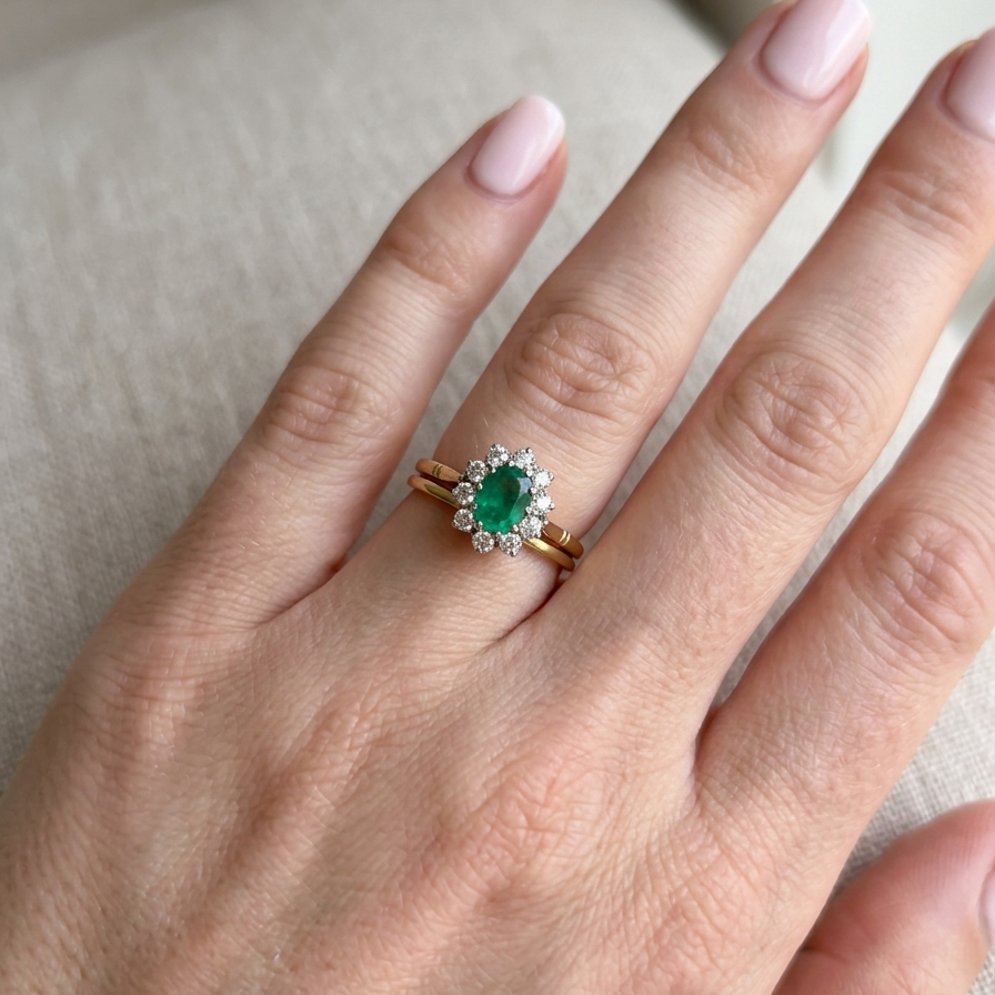 hand Features an oval cut emerald centre stone, vibrant green hues, measures 9x6mm(est 1.75 carats) . Complimented by an outer halo of ten 2.7mm brilliant cut white diamonds (est total 0.60 carats) colour i-j, clarity S.