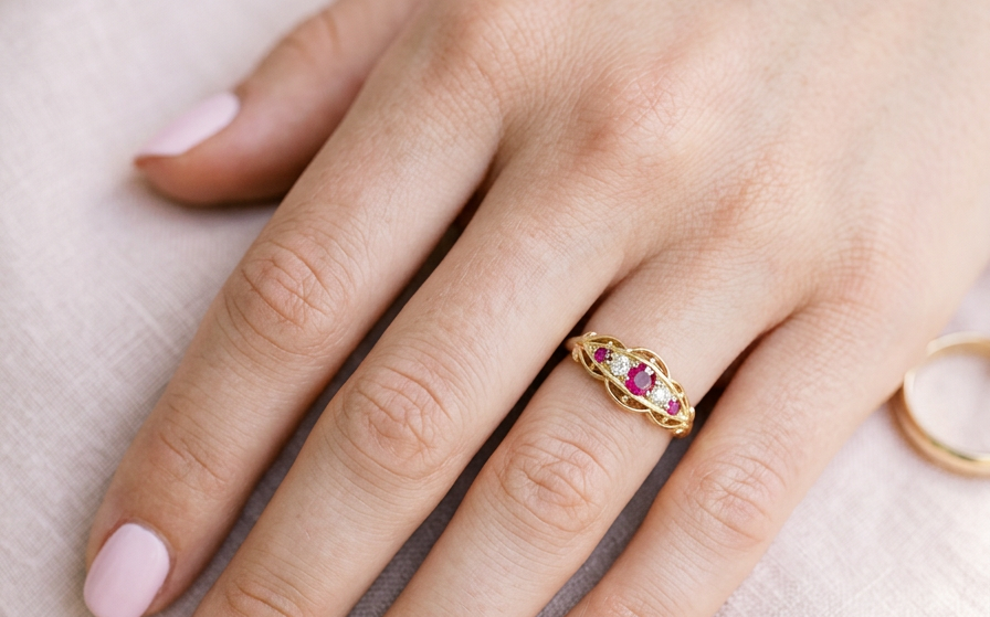 hand Set with three bright rubies, centre 3x2.6mm, each end a 2mm ruby. Each side of the centre stone an old brilliant cut white diamond 2.8mm (est 0.08 carats) . Head measures 17x7mm, weight 3.4grams. 