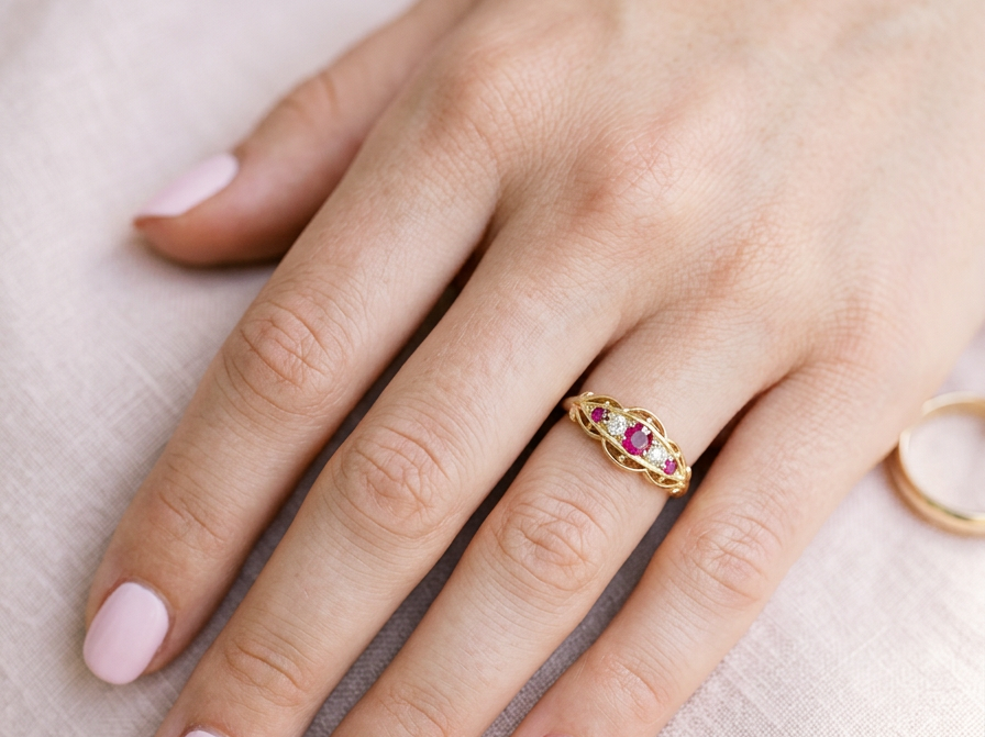 hand Set with three bright rubies, centre 3x2.6mm, each end a 2mm ruby. Each side of the centre stone an old brilliant cut white diamond 2.8mm (est 0.08 carats) . Head measures 17x7mm, weight 3.4grams. 