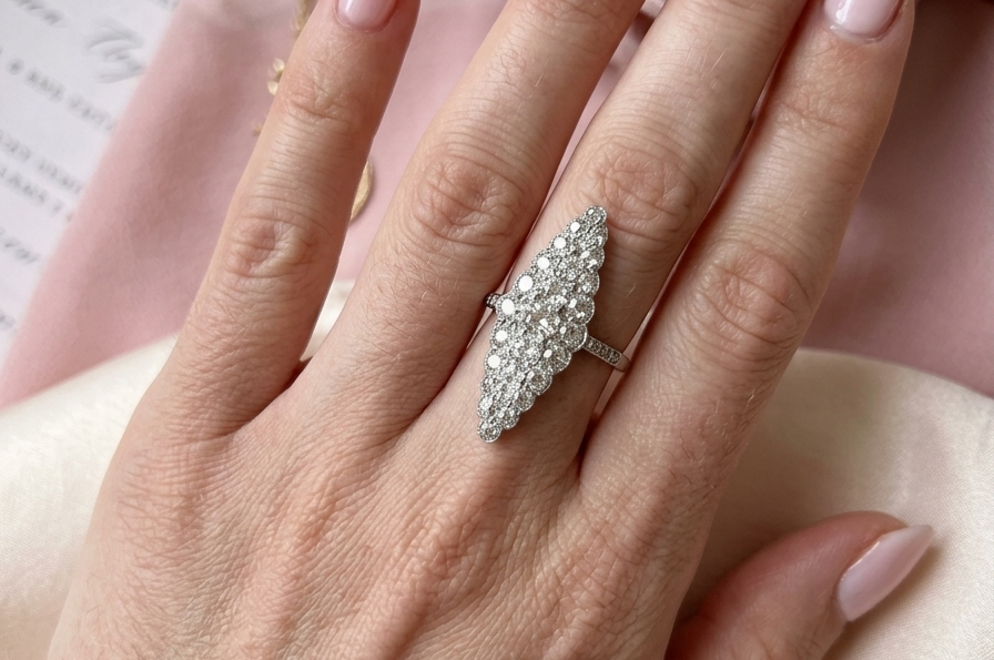hand This is a striking marquise-shaped diamond cluster ring with a very classic, vintage-inspired look.