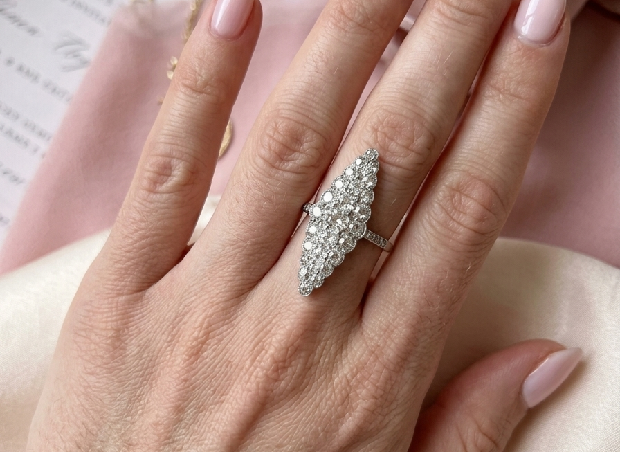 hand This is a striking marquise-shaped diamond cluster ring with a very classic, vintage-inspired look.