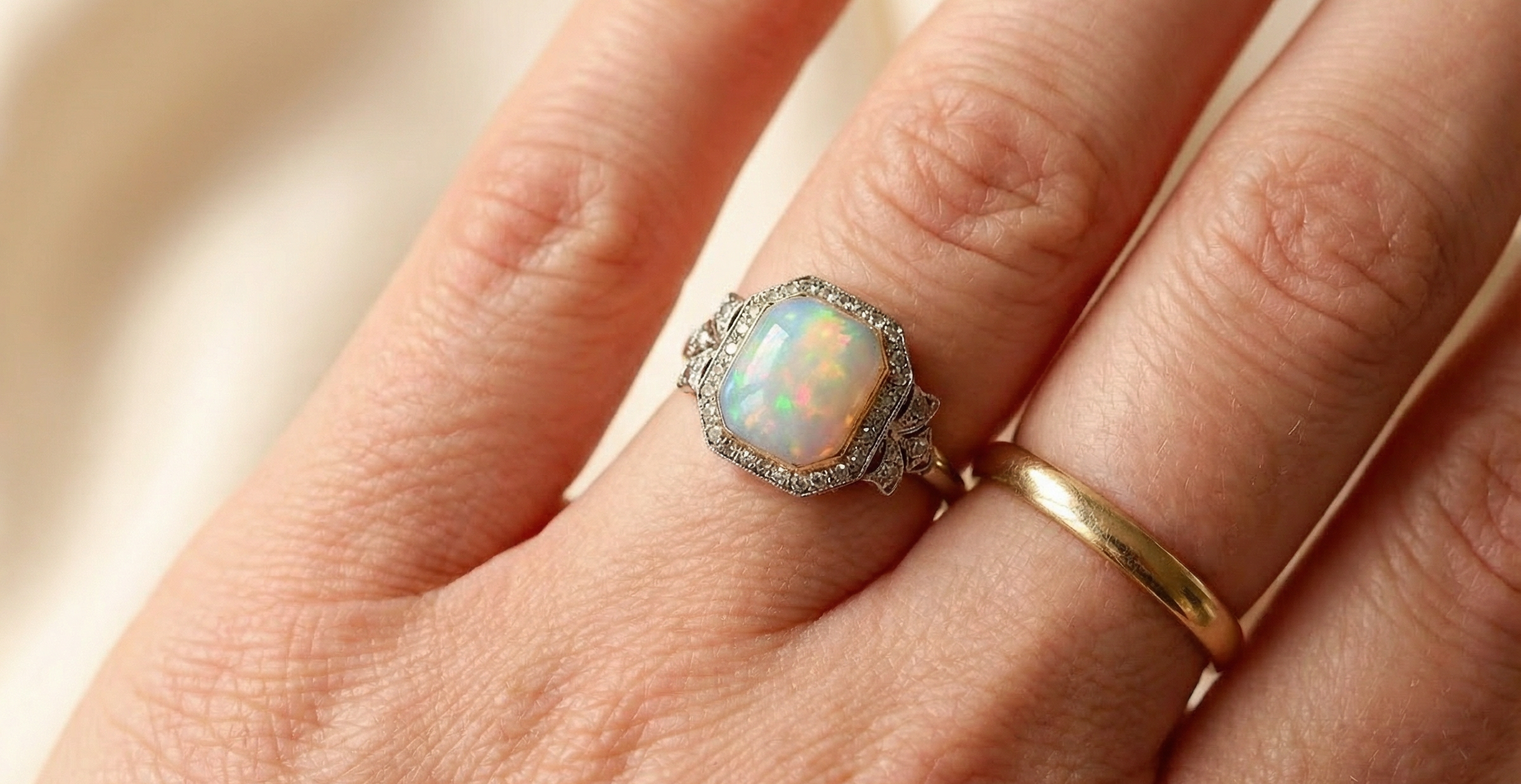 hand cabouchon cut opal shown is cushion shaped, measures 15x13 (5.78 carats) displaying a mass of vibrant colours, from flashes of fireglow orange, luminous greens, and lavender purples.