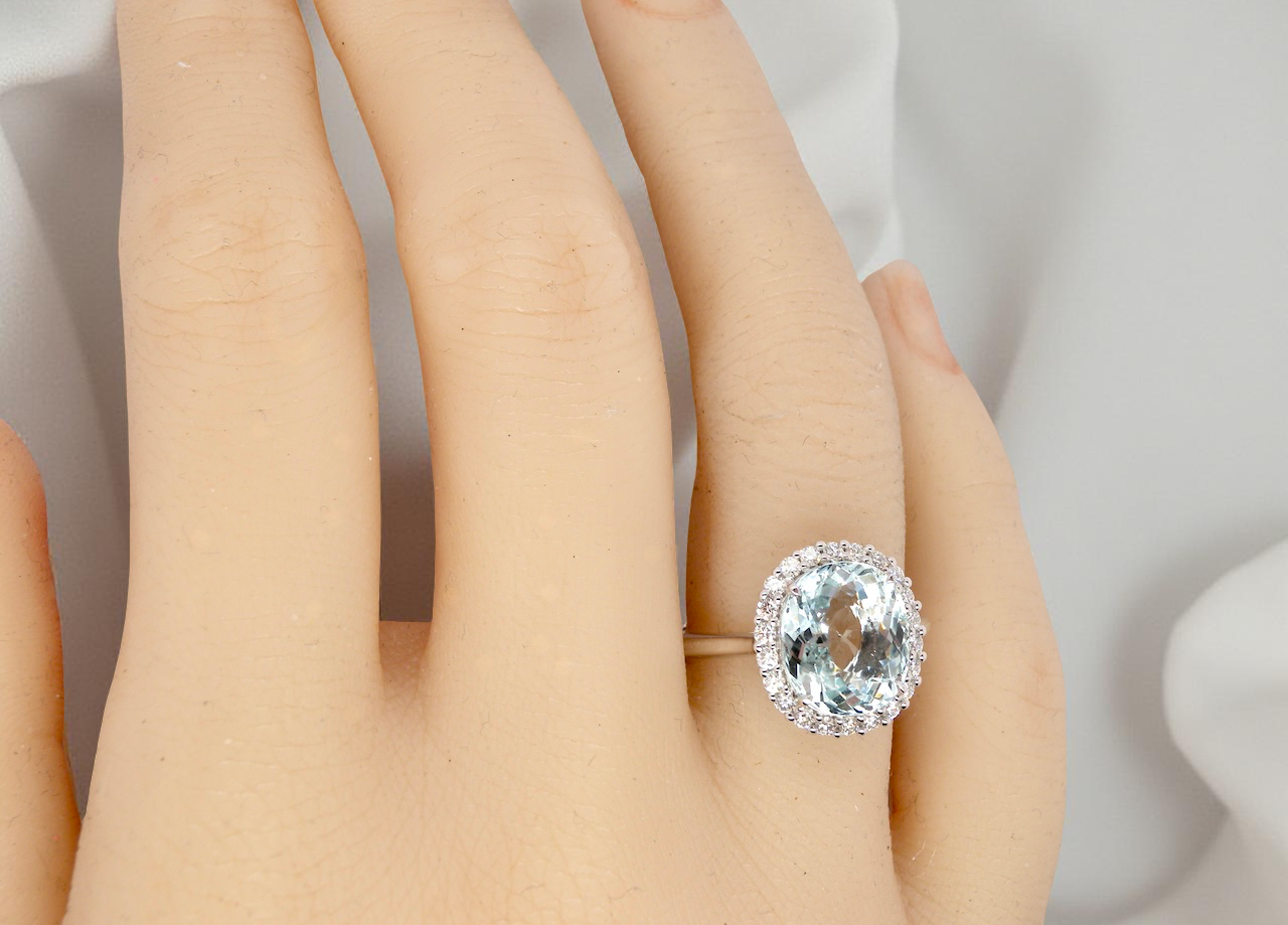 hand elegant cluster ring centred on a beautiful oval aquamarine,