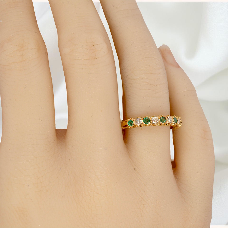 hand half-eternity ring set with alternating emeralds and diamonds.