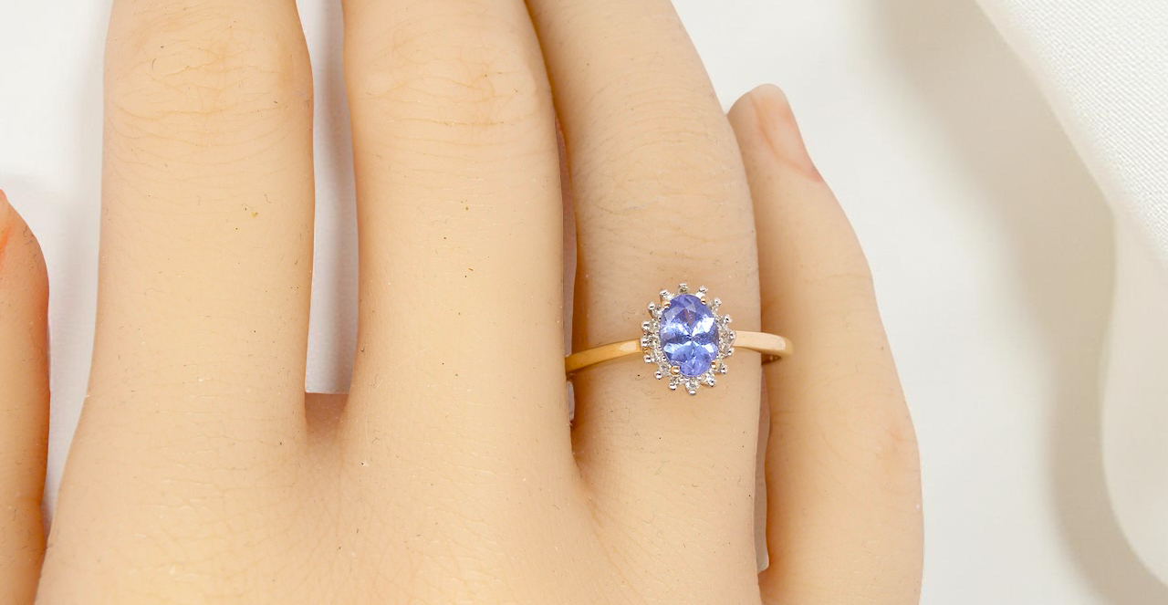hand pretty cluster ring that features an oval cut tanzanite gemstone,