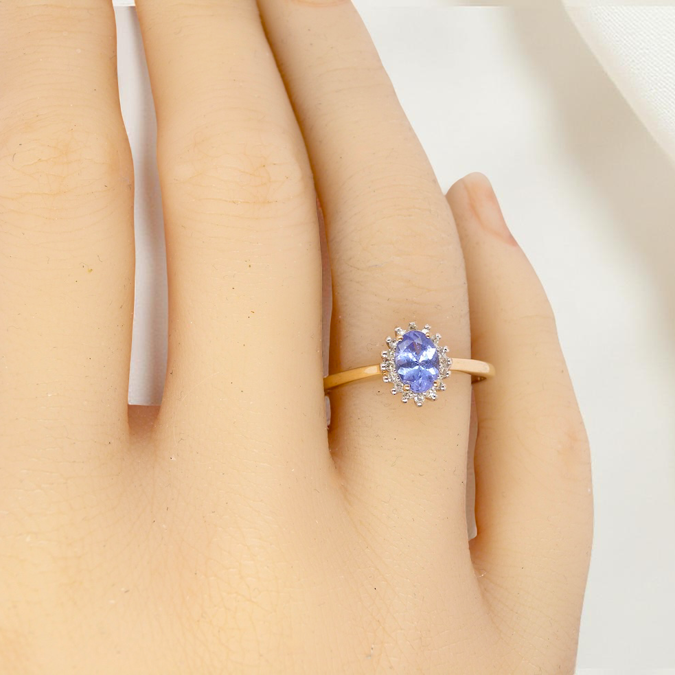 hand pretty cluster ring that features an oval cut tanzanite gemstone,