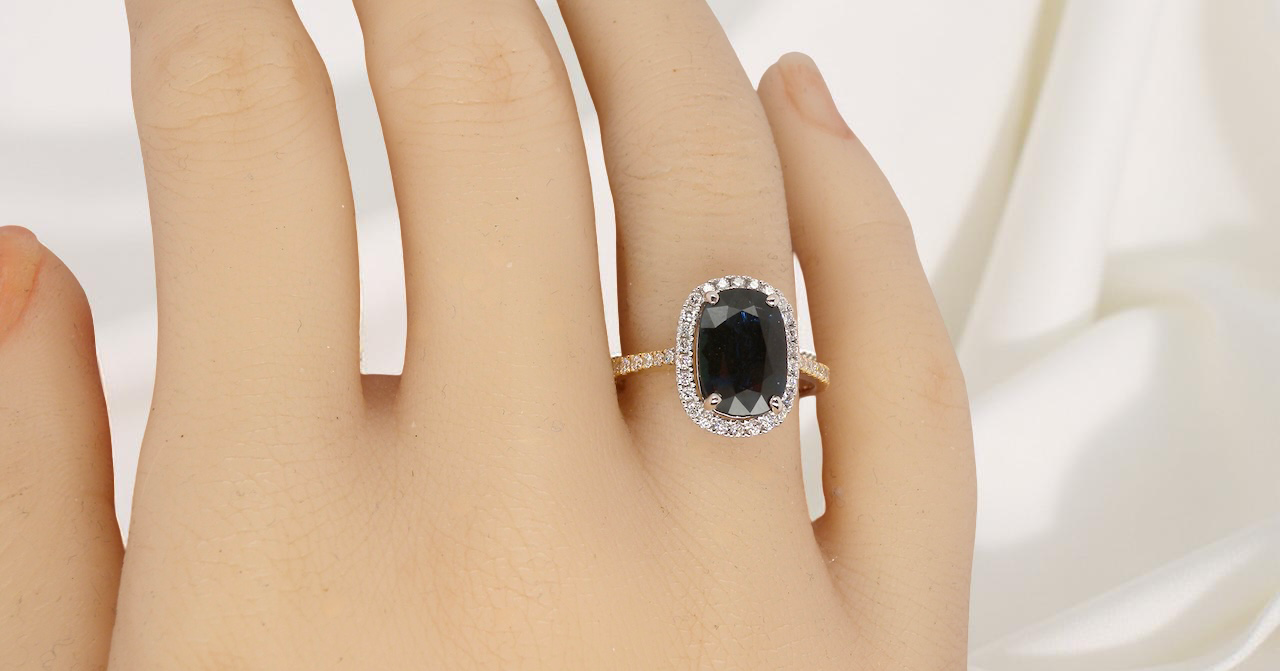 hand striking cluster ring featuring a captivating ink-black blue sapphire,
