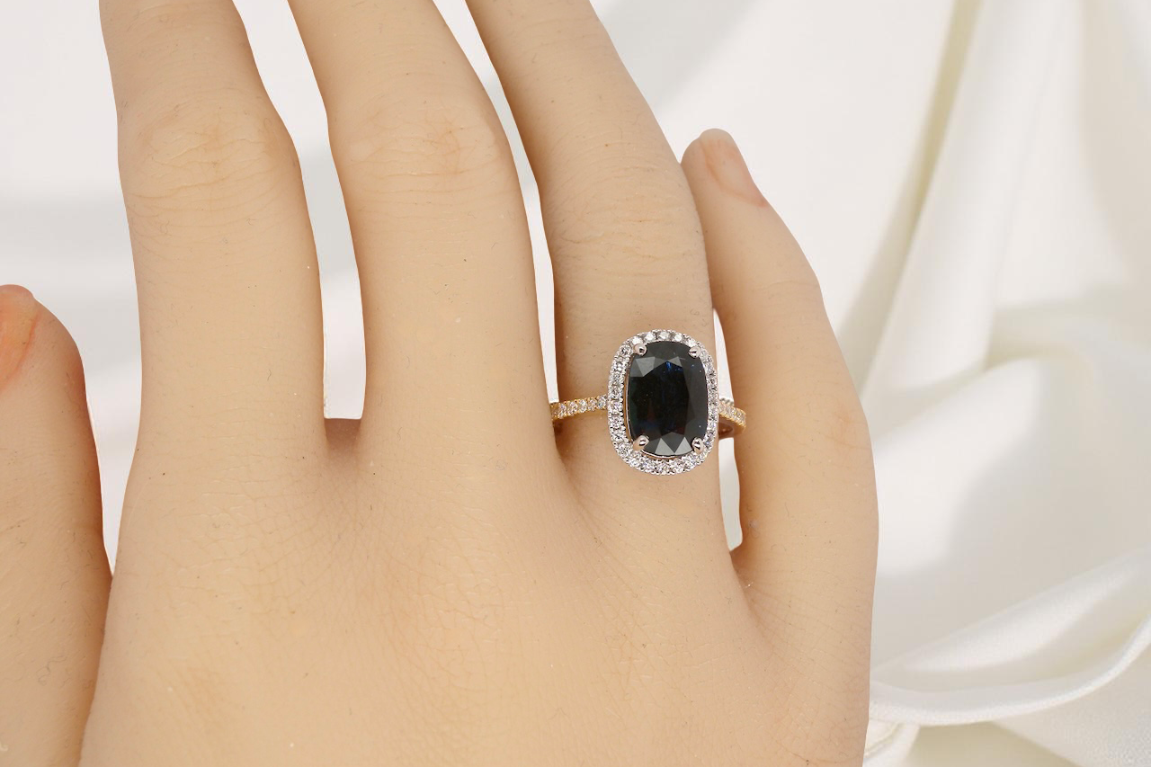 hand striking cluster ring featuring a captivating ink-black blue sapphire,
