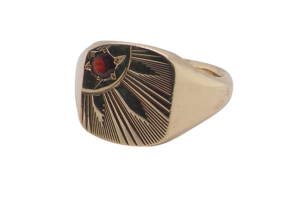 Gold ring with a red gemstone on a white background
