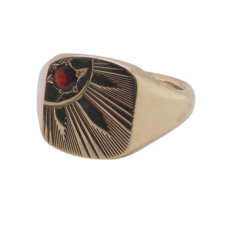 Gold ring with a red gemstone on a white background