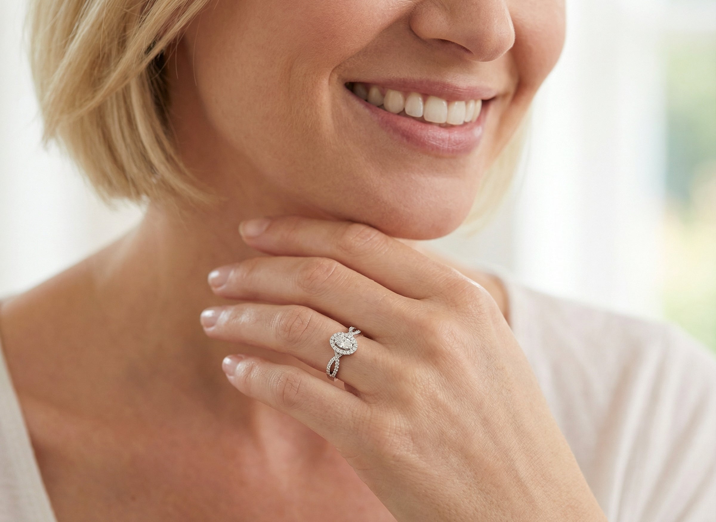 model A 14 carat white gold cluster ring. The centre cluster an oval setting with nine small white diamonds.
Around the outside a halo of sixteen smaller diamonds,