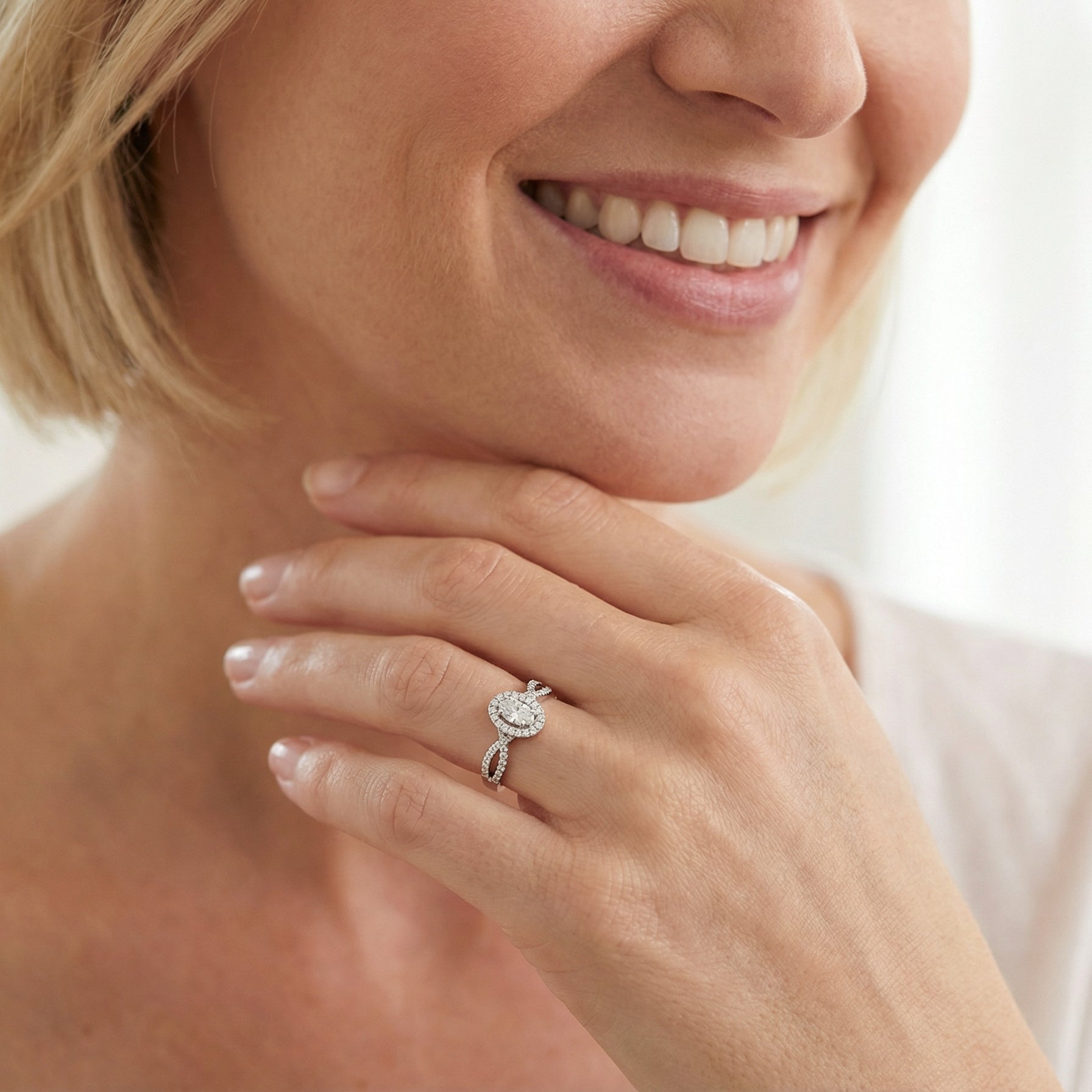 model A 14 carat white gold cluster ring. The centre cluster an oval setting with nine small white diamonds.
Around the outside a halo of sixteen smaller diamonds,
