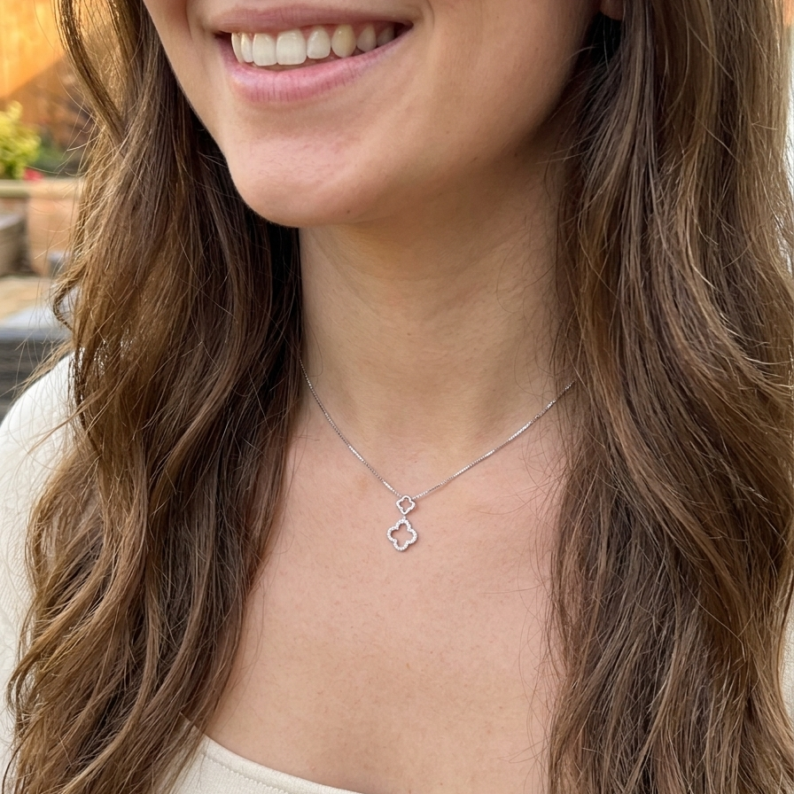 model A 9 carat white gold pendant in the 'Alhambra' style. Set with twenty four small white diamonds, carat total 0.12 carats.