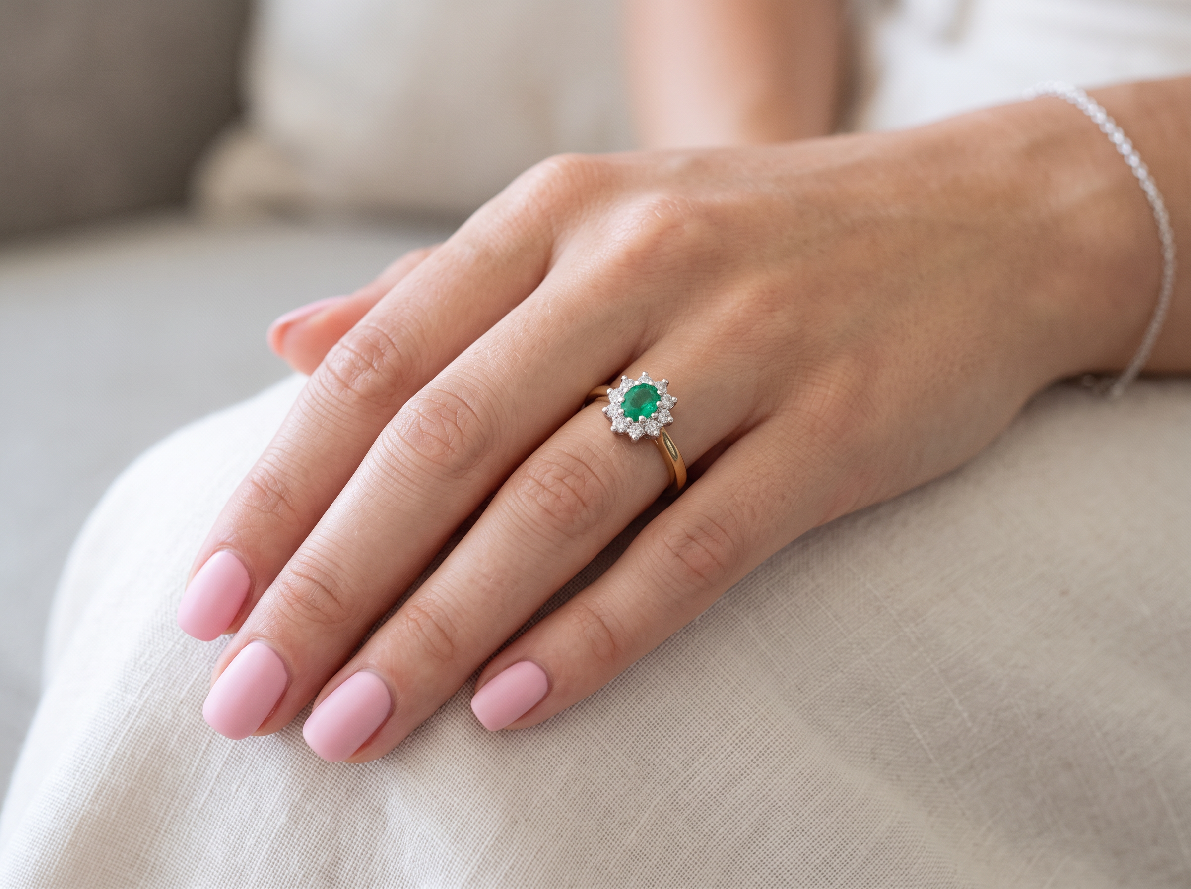 model A classic cluster ring. Features to the centre a round emerald, comlimented by an outer halo of brilliant cut white diamonds